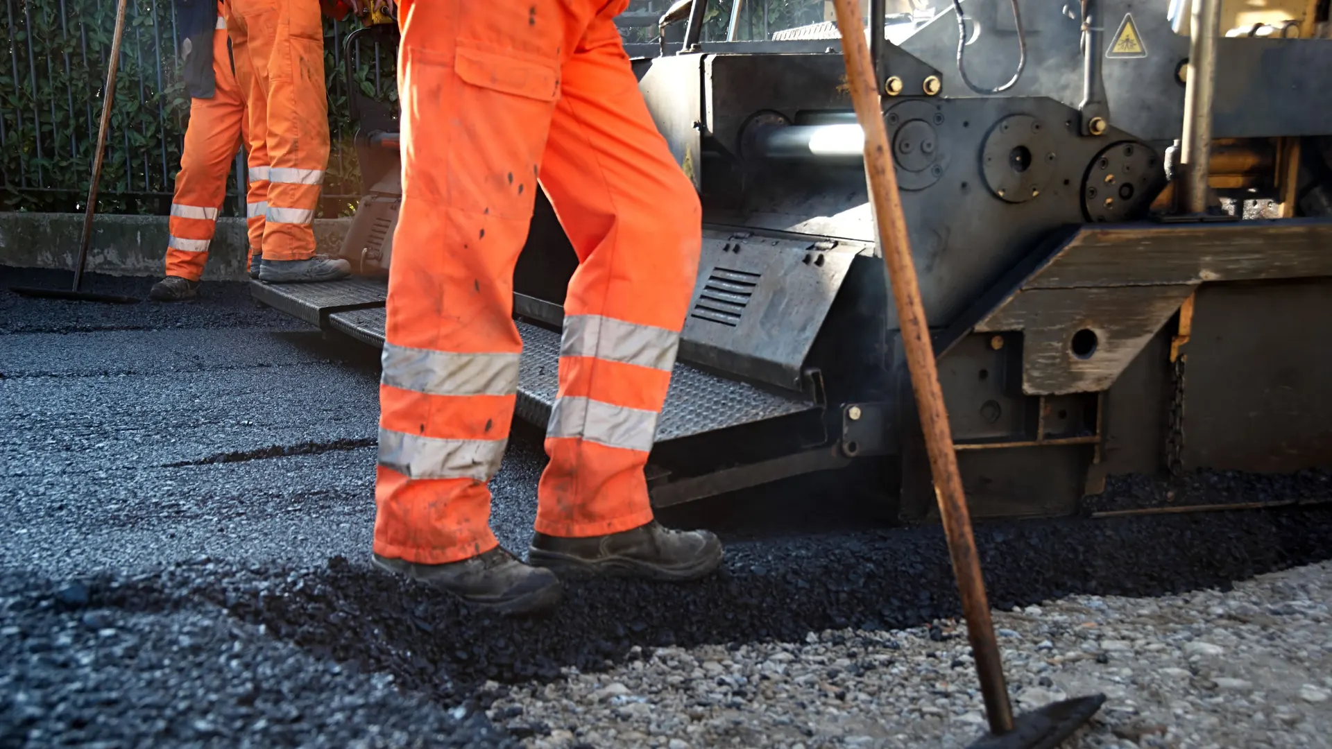 Surfacing crew working beside a paving machine